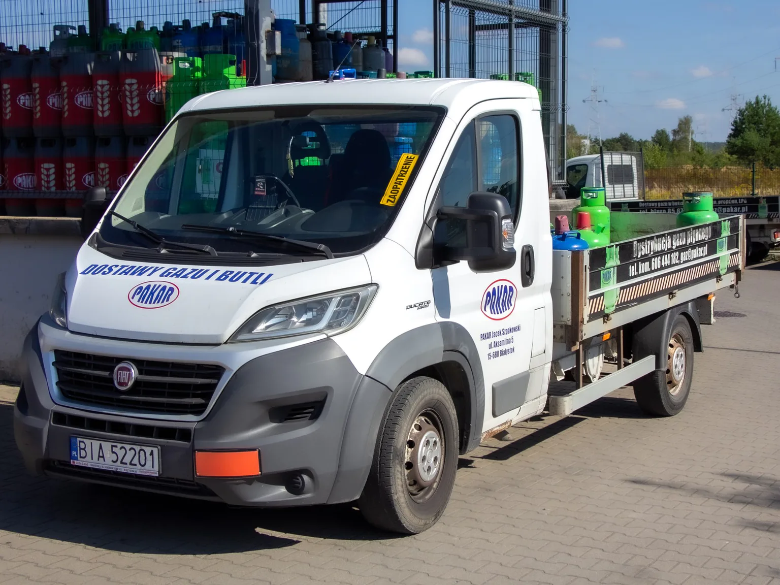 Samochód dostawczy Fiat Ducato PAKAR z napisem „Dostawy gazu i butli” i butlami gazowymi na skrzyni